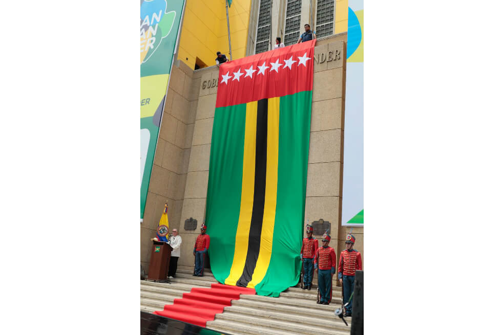 La actual bandera consta de cinco franjas horizontales de colores verde, amarillo y negro; una franja vertical en color rojo, y siete estrellas blancas, que simbolizan cada una de las provincias que constituyen el territorio santandereano. / Cortesía