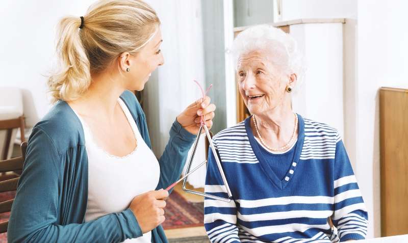 young therapist playing a triangle to senior woman, music therapy , useful especially for people with Alzheimer disease