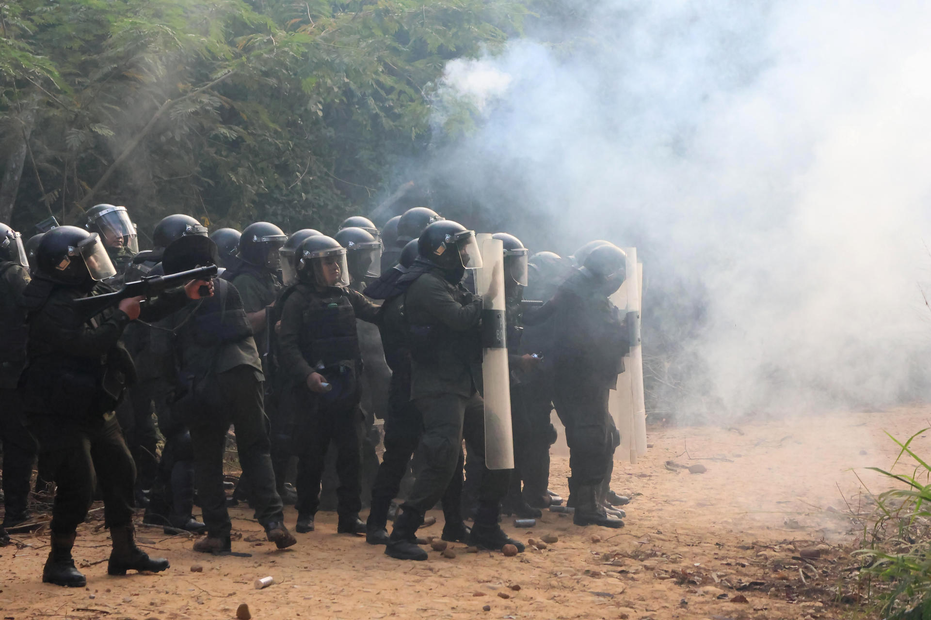 AME8001. SANTA ROSA (BOLIVIA), 03/06/2026.- Integrantes de la Policía de Bolivia controlan a manifestantes durante un bloqueo en el campo petrolero Humberto Suárez este miércoles, en Santa Rosa (Bolivia). La Policía de Bolivia retomó el control de una planta de hidrocarburos en el departamento de Santa Cruz, tomada desde el martes por manifestantes que exigen la renuncia del presidente Rodrigo Paz, en un operativo con gases lacrimógenos que dejó al menos ocho detenidos. EFE/ Juan Carlos Torrejon
