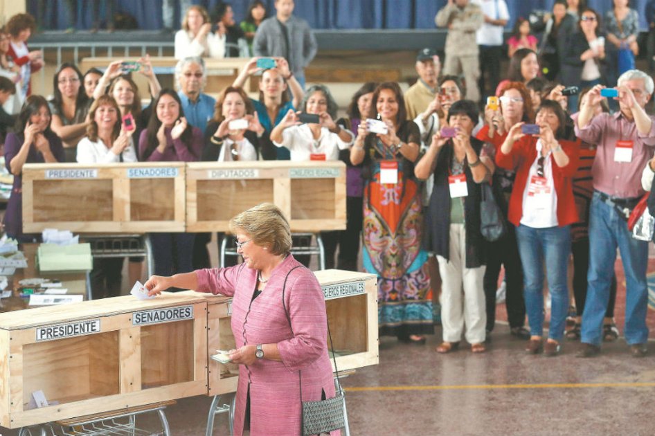 Michelle Bachelet, la candidata favorita en las presidenciales chilenas, deposita su voto durante los comicios. / EFE
