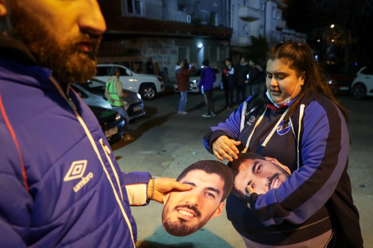 AME4564. MONTEVIDEO (URUGUAY), 21/07/2022.- Aficionados del Nacional de Uruguay reciben caretas del jugador Luis Suárez hoy, en el estadio Gran Parque Central de Montevideo (Uruguay). Con 15.000 caretas de Luis Suárez los fanáticos del uruguayo Nacional pidieron este jueves, en el estadio Gran Parque Central, por el retorno del goleador al equipo en el que debutó como profesional en mayo de 2005. EFE/ Raúl Martínez