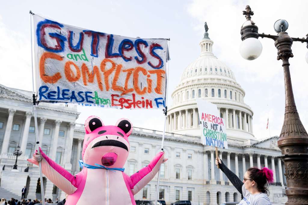 A protester holds a sign related to the release of the Jeffrey Epstein case files outside the US Capitol in Washington, DC, November 12, 2025.