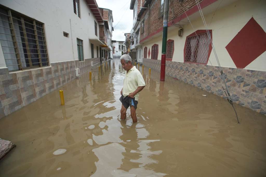 AME7005. CALI (COLOMBIA), 08/04/2025.- Un hombre atraviesa una calle inundada este martes, en Cali (Colombia). En la madrugada de este martes se presentaron fuertes lluvias que provocaron el desbordamiento de un canal de aguas en el barrio Gaitán, en Cali, Colombia. EFE/ Ernesto Guzmán
