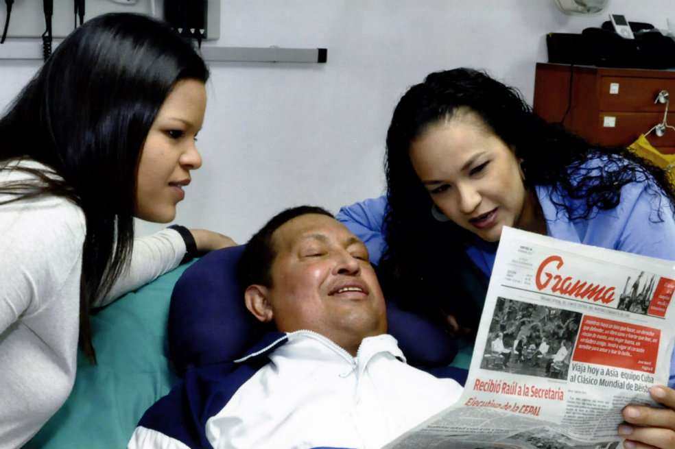 Una de las fotografías del presidente Hugo Chávez en su lecho de enfermo en Cuba, acompañado por sus dos hijas mayores: Rosa Virginia y María. / AFP