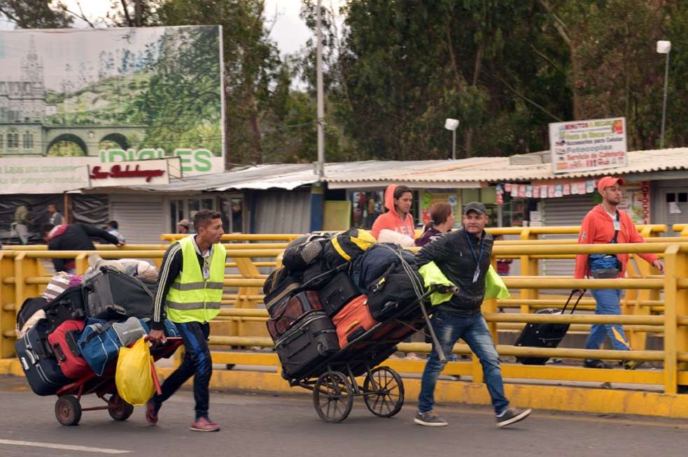 Migrantes venezolanos caminan con sus pertenencias por Rumichaca, Ecuador. / EFE