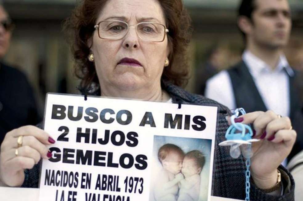 Una de las víctimas del caso de bebés sostiene un cartel en el pide información sobre sus hijos. / Archivo Agencias