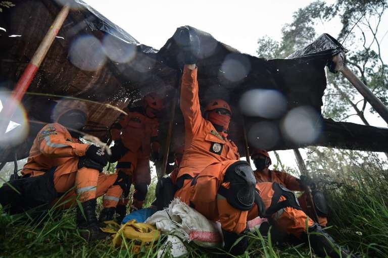 Funcionarios de la Defensa Civil bajo una carpa