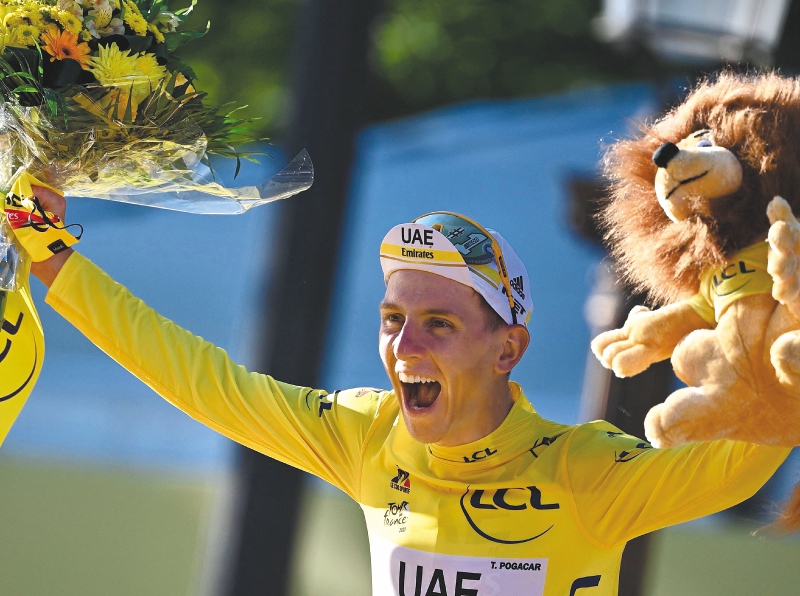 Winner Team UAE Emirates' Tadej Pogacar of Slovenia celebrates his overall leader yellow jersey on the podium at the end of the 21th and last stage of the 108th edition of the Tour de France cycling race, 108 km between Chatou and Paris Champs-Elysees, on July 18, 2021. / AFP / Anne-Christine POUJOULAT