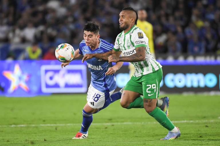 Daniel Ruiz (Millonarios) y Andrés Sarmiento luchan por una pelota.