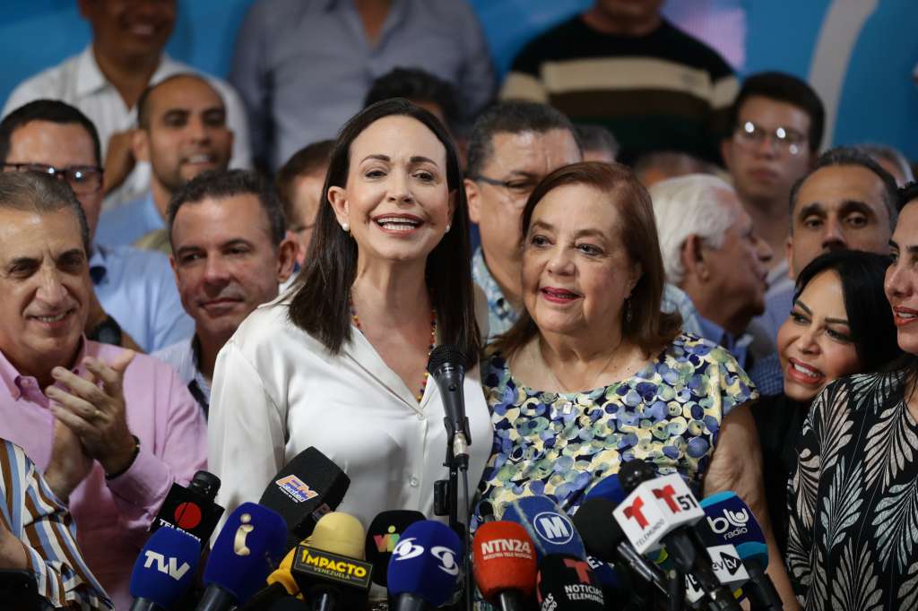 AME1083. CARACAS (VENEZUELA), 22/03/2024.- La líder antichavista María Corina Machado (izq.) presenta durante una rueda de prensa a la historiadora Corina Yoris (der.) como candidata para las elecciones presidenciales del próximo 28 de julio, en vista de la inhabilitación que impide competir a la política, este viernes en Caracas (Venezuela). En declaraciones a la prensa, Machado aseguró que la decisión "surgió del seno de la discusión de las fuerzas unitarias" y forma parte de un mecanismo acordado para hacer "frente a este obstáculo", en referencia a su inhabilitación, ratificada en enero por el Tribunal Supremo de Justicia (TSJ), una sanción a la calificó como "un acto írrito, totalmente inconstitucional y cobarde". EFE/ Rayner Peña R.