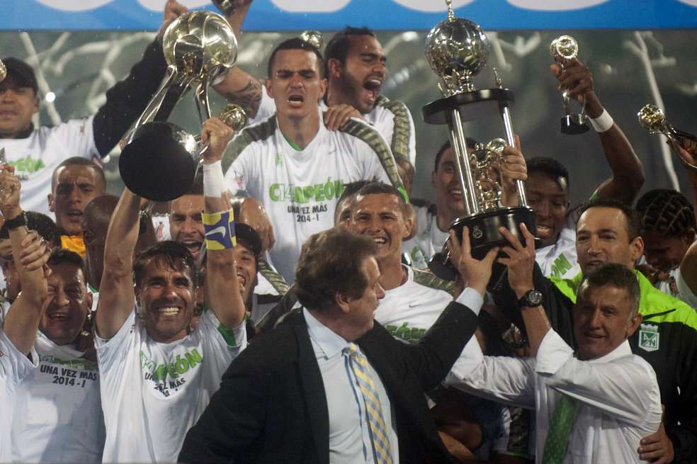 El técnico Juan Carlos Osorio exhibe con orgullo la copa de campeón. / AFP