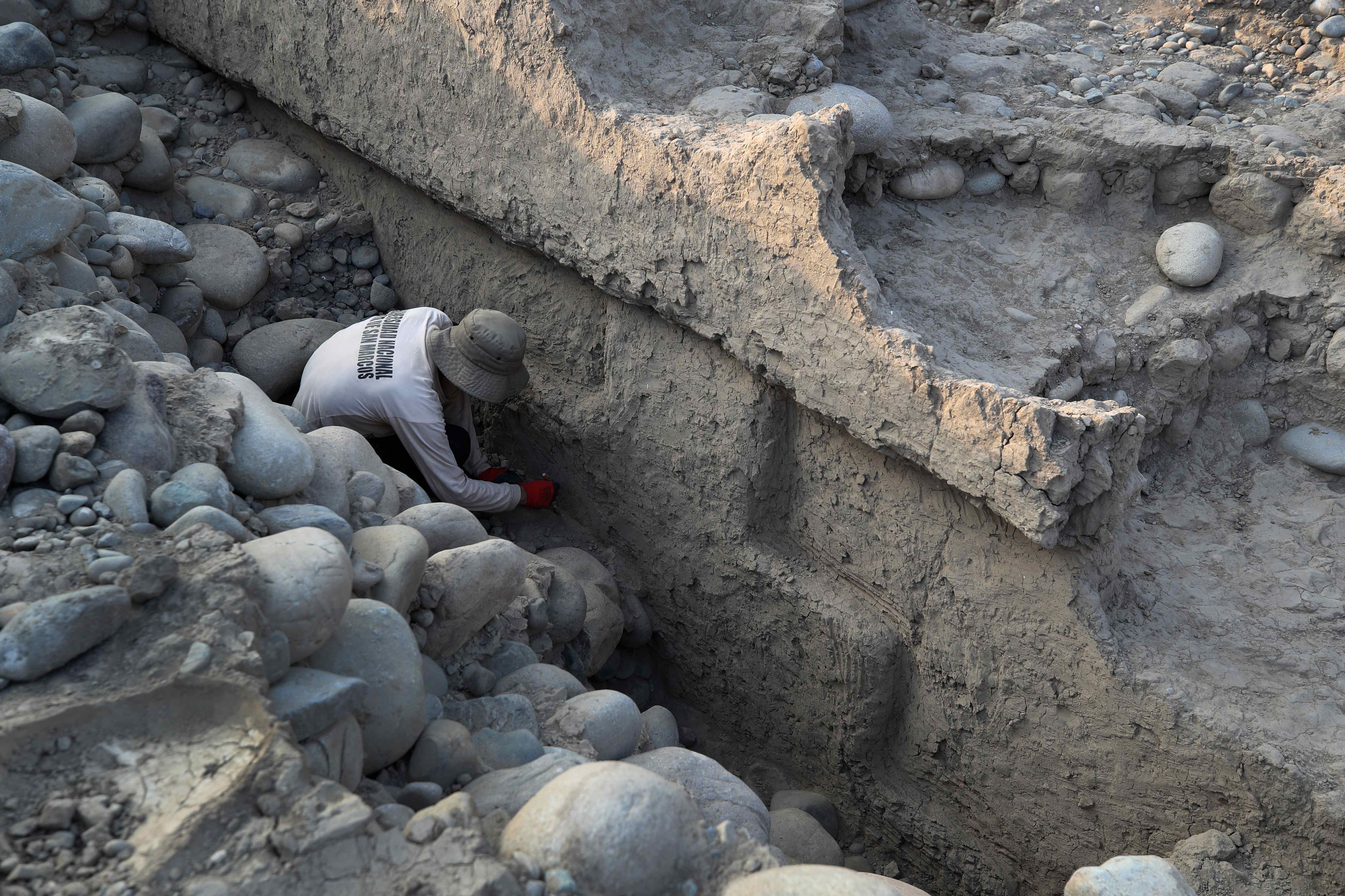 ACOMPAÑA CRÓNICA LIM01. LIMA (PERÚ), 15/05/2023.- Un arqueólogo limpia una "chacana" (cruz andina), hallada en un templo de unos 4.000 años de antigüedad en la costa central de Perú, el 12 de mayo en la provincia de Huaral al sur de Lima (Perú). Un grupo de arqueólogos halló un templo de unos 4.000 años de antigüedad en la costa central de Perú que atesora en uno de sus frisos una cruz andina que, de estar completa, tal y como sospechan los expertos, sería la evidencia más antigua en Suramérica de una "chacana", nombre con el que son conocidas. EFE/ Paolo Aguilar