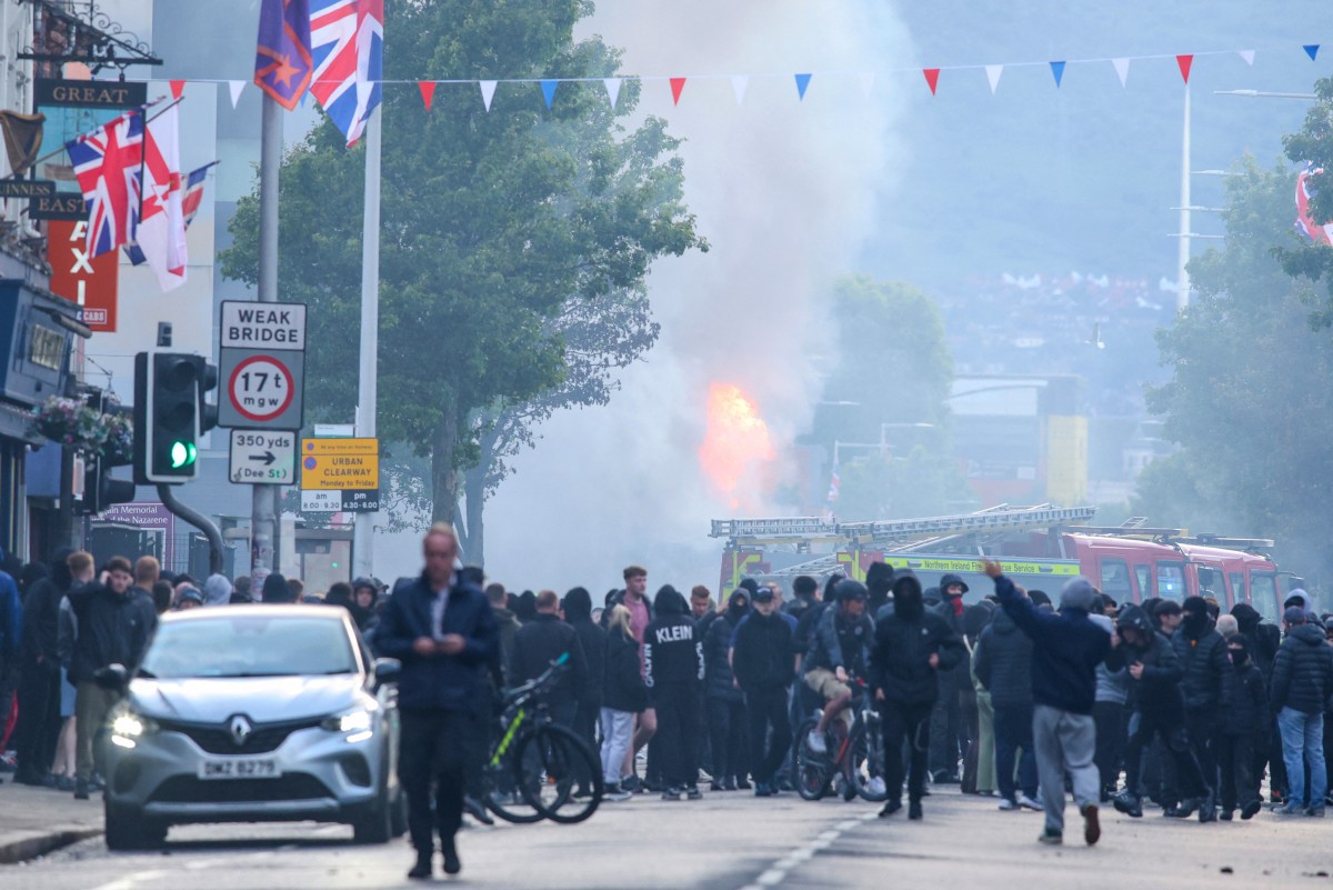 A burning bus is seen as protesters gather on the Newtownards road in east Belfast, Northern Ireland, in the evening of June 9, 2026.