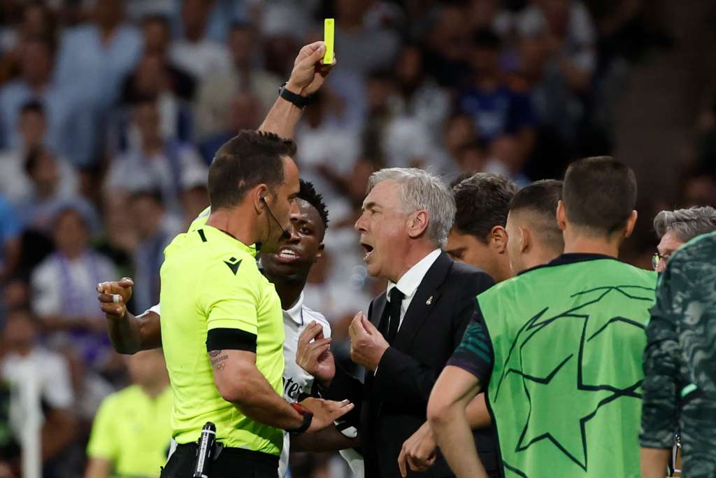MADRID, 09/05/2023.- El árbitro Artur Dias (i) muestra una tarjeta amarilla al entrenador del Real Madrid, Carlo Ancelotti, durante el partido de ida de las semifinales de la Liga de Campeones que Real Madrid y Manchester City disputan este martes en el estadio Santiago Bernabéu, en Madrid. EFE/Juanjo Martín