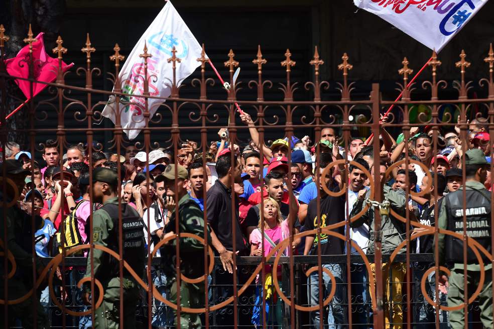 Seguidores del Gobierno protestan al frente del edificio de la Asamblea Nacional. Varios diputados opositores fueron atacados al entrar a la sesión de ayer. / AFP