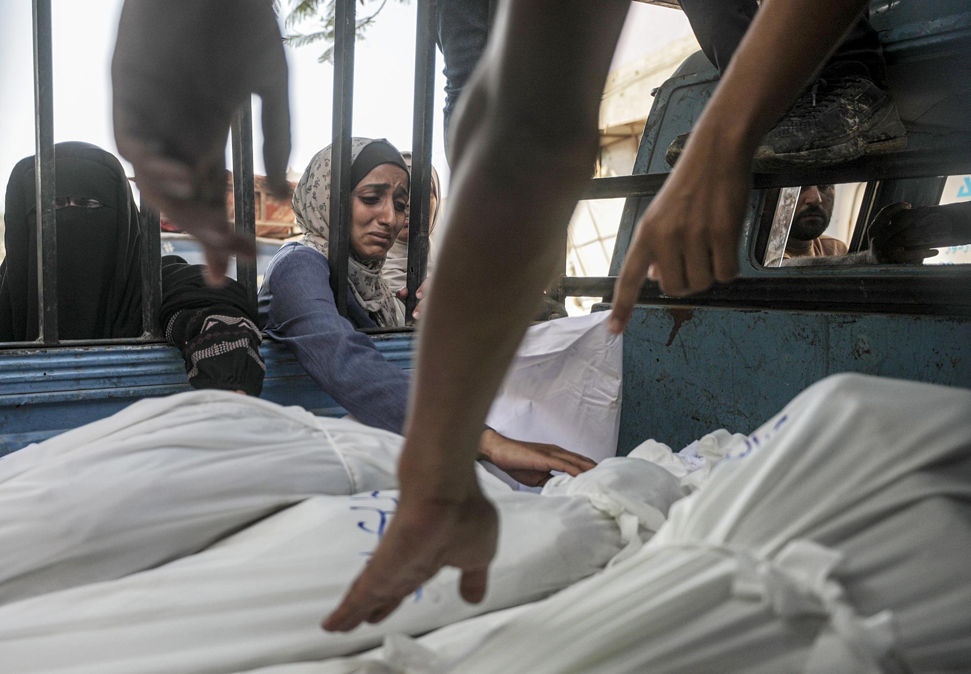 GAZA CITY (---), 23/07/2025.- A woman mourns over shrouded bodies of Mushtaha family members at the Al-Shifa in Gaza City, 23 July 2025. According to the Palestinian Ministry of Health in Gaza, more than 36 Palestinians were killed, tem of them from the Mushtaha family, following Israeli airstrikes last night and early today. EFE/EPA/MOHAMMED SABER