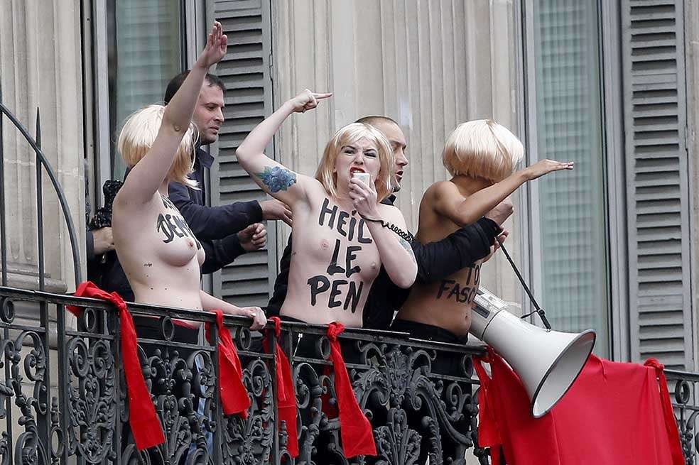 Activistas de Femen evacuadas por agentes de seguridad mientras protestaban a pecho descubierto y con el eslogan: “Le Pen TOP fascist”. EFE