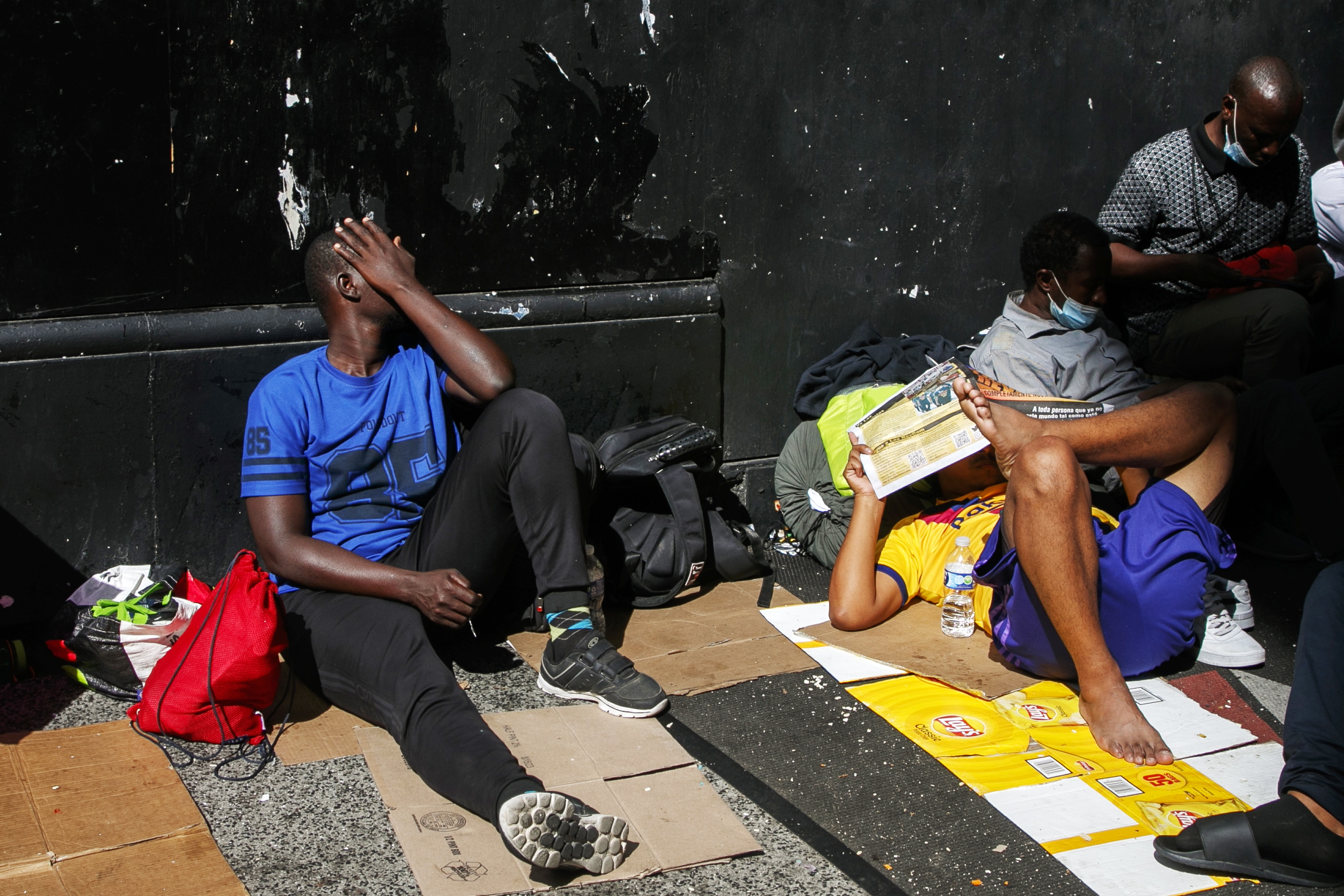 New York (United States), 01/08/2023.- Migrants wait outside of the former Roosevelt Hotel in New York, New York USA, 01 August 2023. The former hotel, which is the city's largest intake center for migrants, is filled to capacity and migrants are being forced to sleep on the sidewalk. (Nueva York) EFE/EPA/SARAH YENESEL 23829