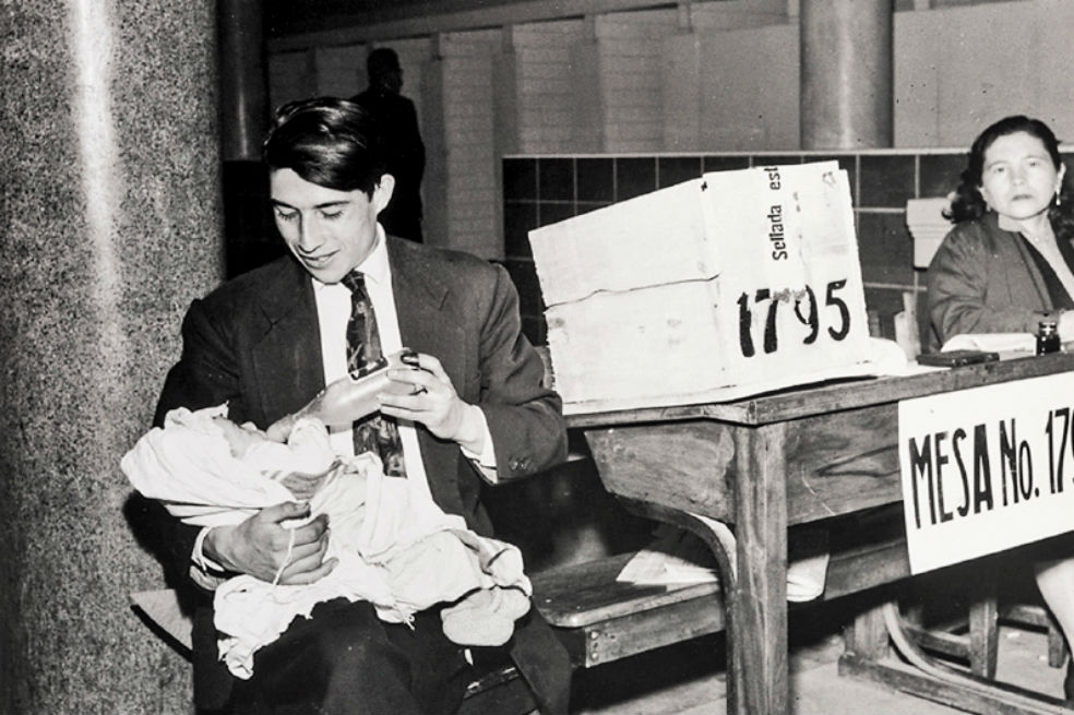 Voto femenino. Padre dando tetero al hijo, 1957. / Banco de la República