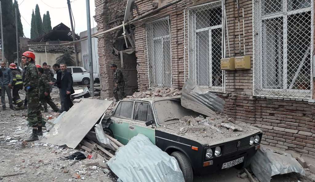 El personal de emergencias trabaja en un área dañada de la ciudad de Ganja (Azerbaiyán) luego de un ataque con cohetes armenios el 4 de octubre de 2020, durante los combates en curso entre Armenia y Azerbaiyán por la región separatista de Nagorno-Karabaj.