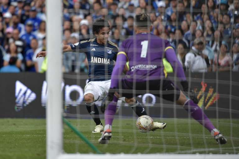 El extremo de Millonarios, Daniel Mantilla, conduce el balón ante la mirada del portero Aldair Quintana.