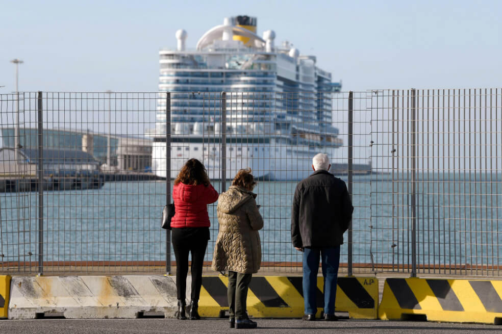La gente mira el crucero de la Costa Smeralda, que está atracado en el puerto de Civitavecchia, a 70 km al norte de Roma, el 30 de enero de 2020. / AFP