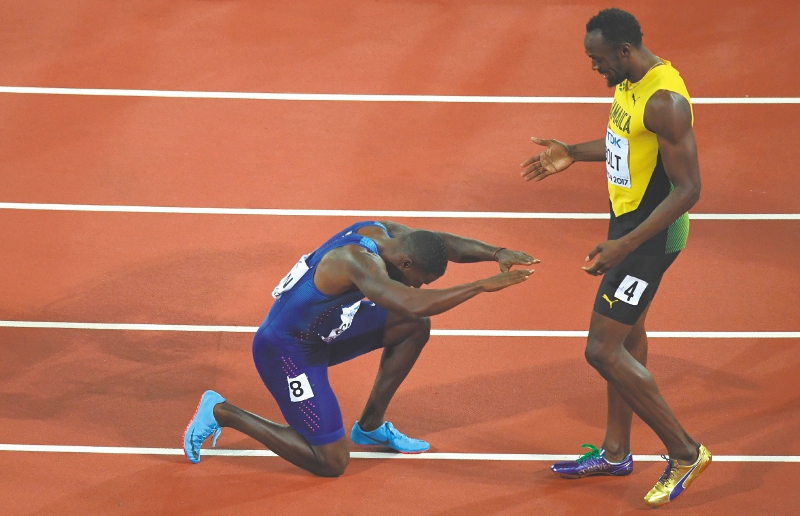 El nuevo campeón mundial, Justin Gatlin, le hace honores al mejor velocista de todos los tiempos, Usain Bolt.