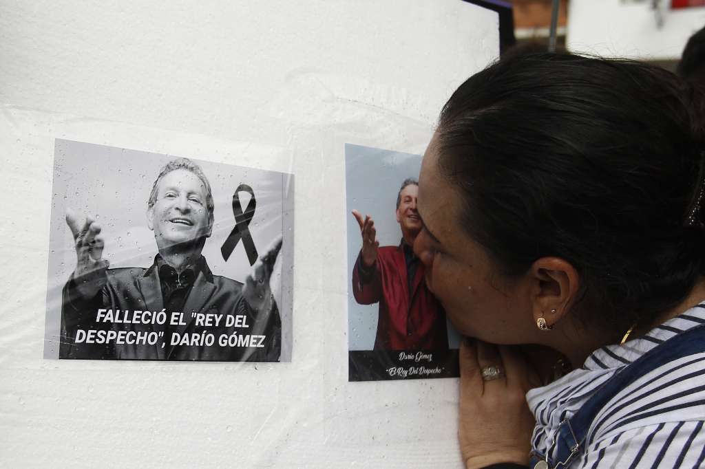 AME5706. MEDELLÍN (COLOMBIA), 27/07/2022.- Una mujer le da un beso a una fotografía del cantante colombiano Darío Gómez, hoy, a las afueras de las instalaciones de Medicina Legal, en Medellín (Colombia). Seguidores del cantautor Darío Gómez, popularizado como "El rey del despecho", esperan afuera de medicina legal a que salga el cortejo fúnebre con el cuerpo del cantante, rumbo al coliseo Yesid Santos para rendirle homenaje. El cuerpo permanecerá en cámara ardiente desde este miércoles a las 9:00 p.m. y hasta el sábado 30 de julio a las 11:00 a.m. para que sus seguidores puedan darle el último adiós, por disposición de la familia del artista. EFE/ Luis Eduardo Noriega A.