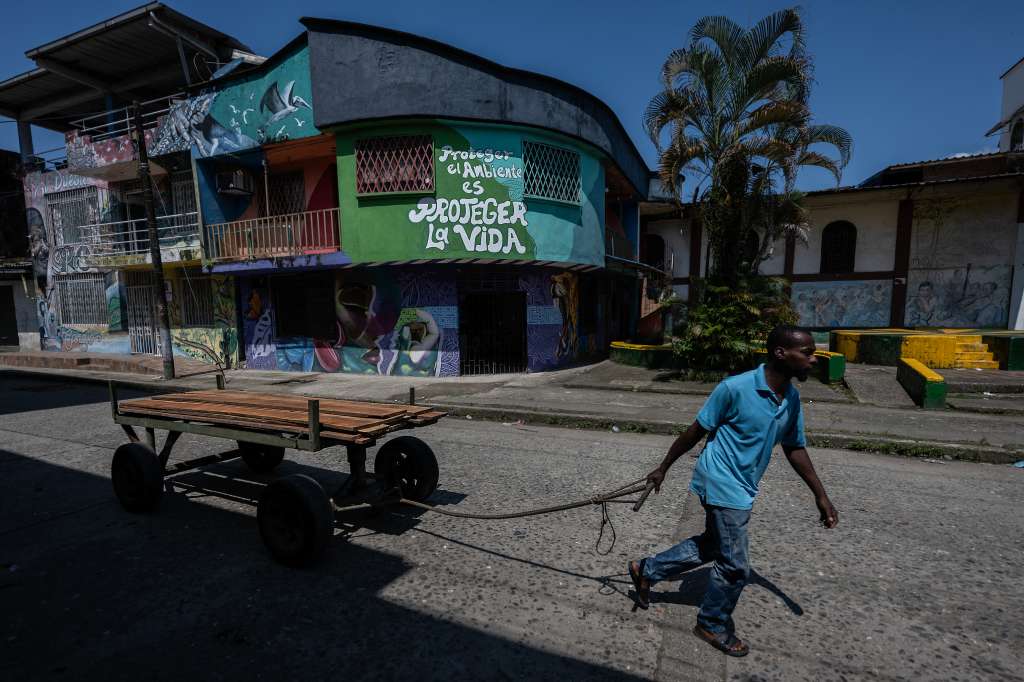 A man pulls a cart loaded with wood on a street in Buenaventura, Valle del Cauca department, Colombia, on September 4, 2024.