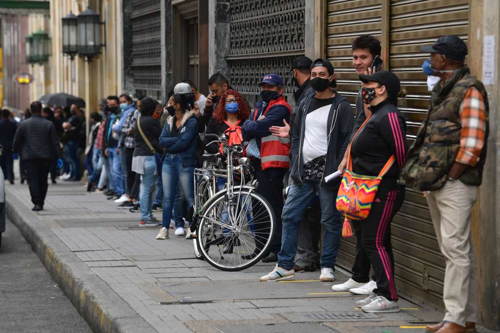 Personas hacen largas filas en el centro de Bogotá para reclamar sus cesantías debido a la crisis por el nuevo coronavirus