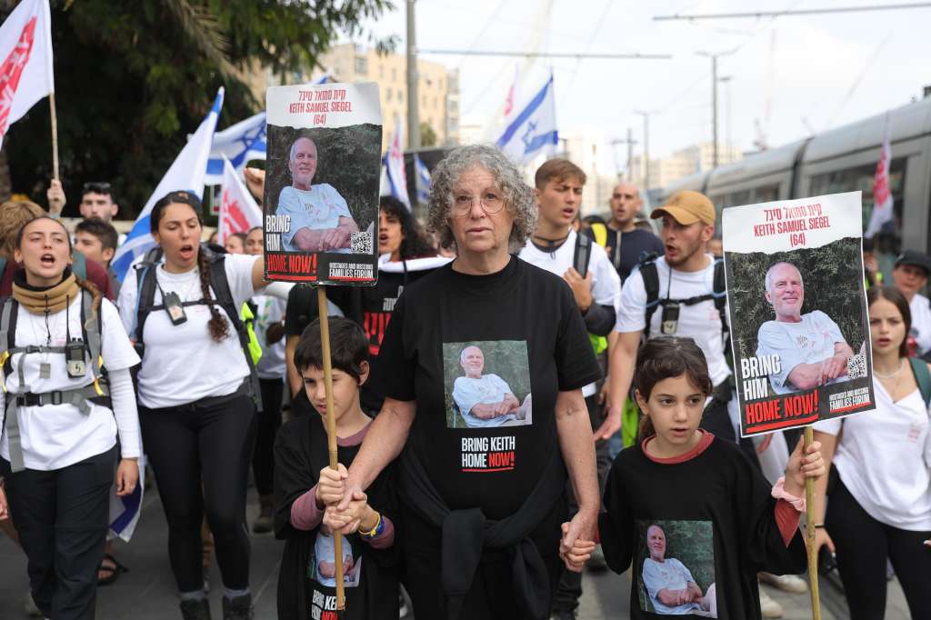 Jerusalem (-), 28/12/2023.- Aviva Siegel (C) holds a picture of her husband, Keith Siegel, as she marches along with her grandchildren and Israeli youths calling for the return of the Israeli hostages held by Hamas in Gaza, in Jerusalem, 28 December 2023. Aviva Siegel, who was released on 26 November from Hamas captivity in Gaza during a hostage deal, joined Israel youth who are on a five-day march calling for the release of the Israeli hostages, which started in Tel Aviv towards the Israeli Knesset. According to the Israeli army, 129 Israelis are still held hostage in Gaza following the 07 October Hamas attack on Israel. (Jerusalén) EFE/EPA/ABIR SULTAN