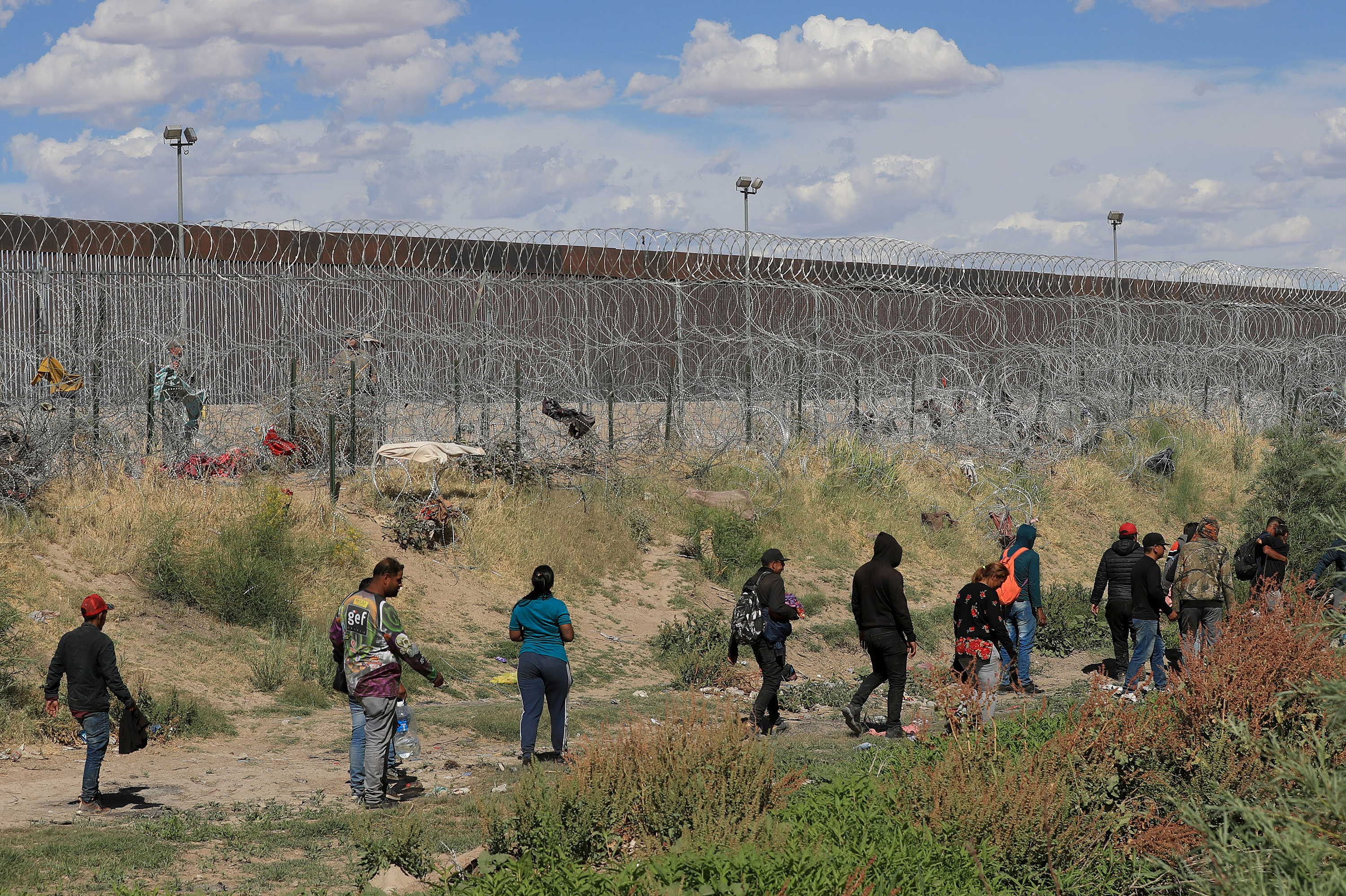 MEX9188. CIUDAD JUÁREZ (MÉXICO), 28/05/2024.- Migrantes caminan cerca del muro que separa la frontera estadounidense, el 26 de mayo de 2024 en Ciudad Juárez, Chihuahua (México). Pese a las crecientes deportaciones y operativos de Estados Unidos y México, los migrantes en el límite de la mexicana Ciudad Juárez con El Paso estadounidense insisten en cruzar el fronterizo río Bravo (o Grande) de forma irregular. EFE/Luis Torres