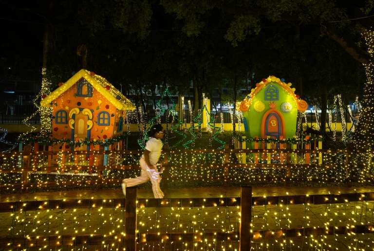 AME234. SANTO DOMINGO (REPÚBLICA DOMINICANA), 23/12/2025.- Una niña corre en el parque temático Villa Navidad este lunes, en Santo Domingo (República Dominicana). EFE/ Orlando Barría