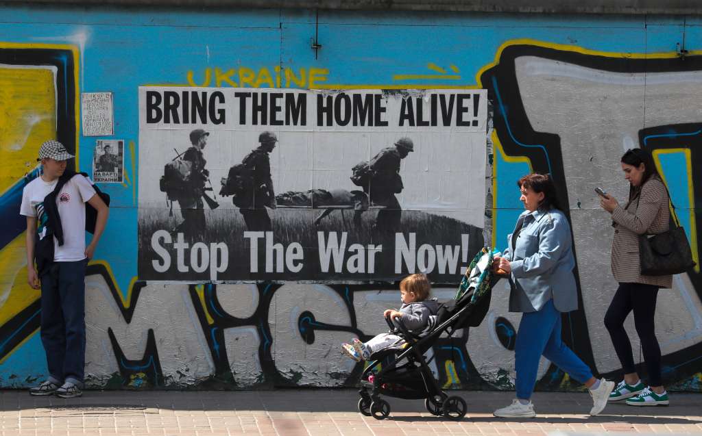 Kyiv (Ukraine), 11/05/2023.- People walk past an anti-war poster in downtown Kyiv, Ukraine, 11 May 2023 amid the Russian invasion. Russian troops entered Ukrainian territory on 24 February 2022, starting a conflict that has provoked destruction and a humanitarian crisis. (Rusia, Ucrania) EFE/EPA/SERGEY DOLZHENKO