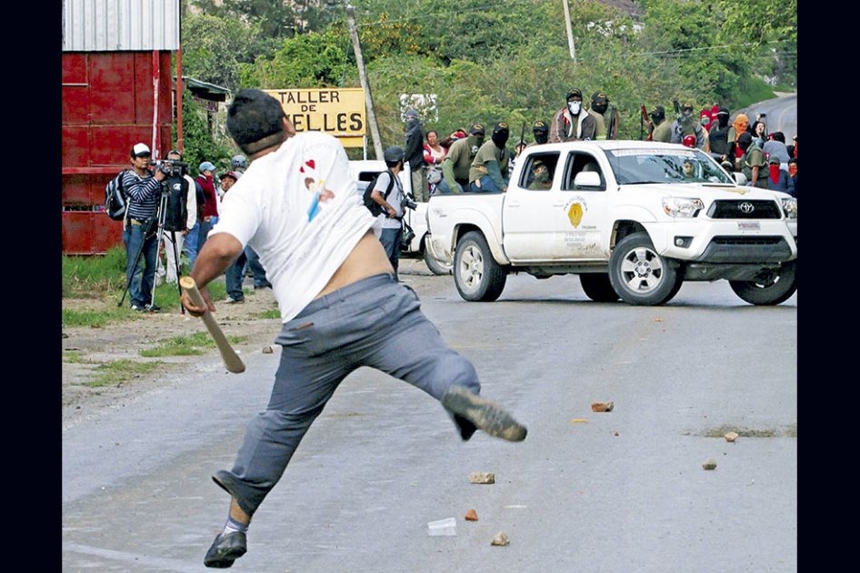Un hombre se enfrenta a los policías comunitarios, que fueron expulsados del auditorio del Ayuntamiento de Tixtla (sur de Guerrero, México). EFE