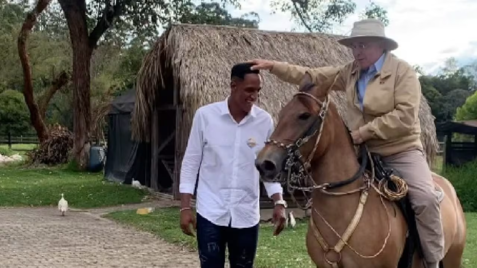 El expresidente Álvaro Uribe Vélez juega dando vueltas a caballo agarrado de la cabeza del futbolista Yerry Mina.