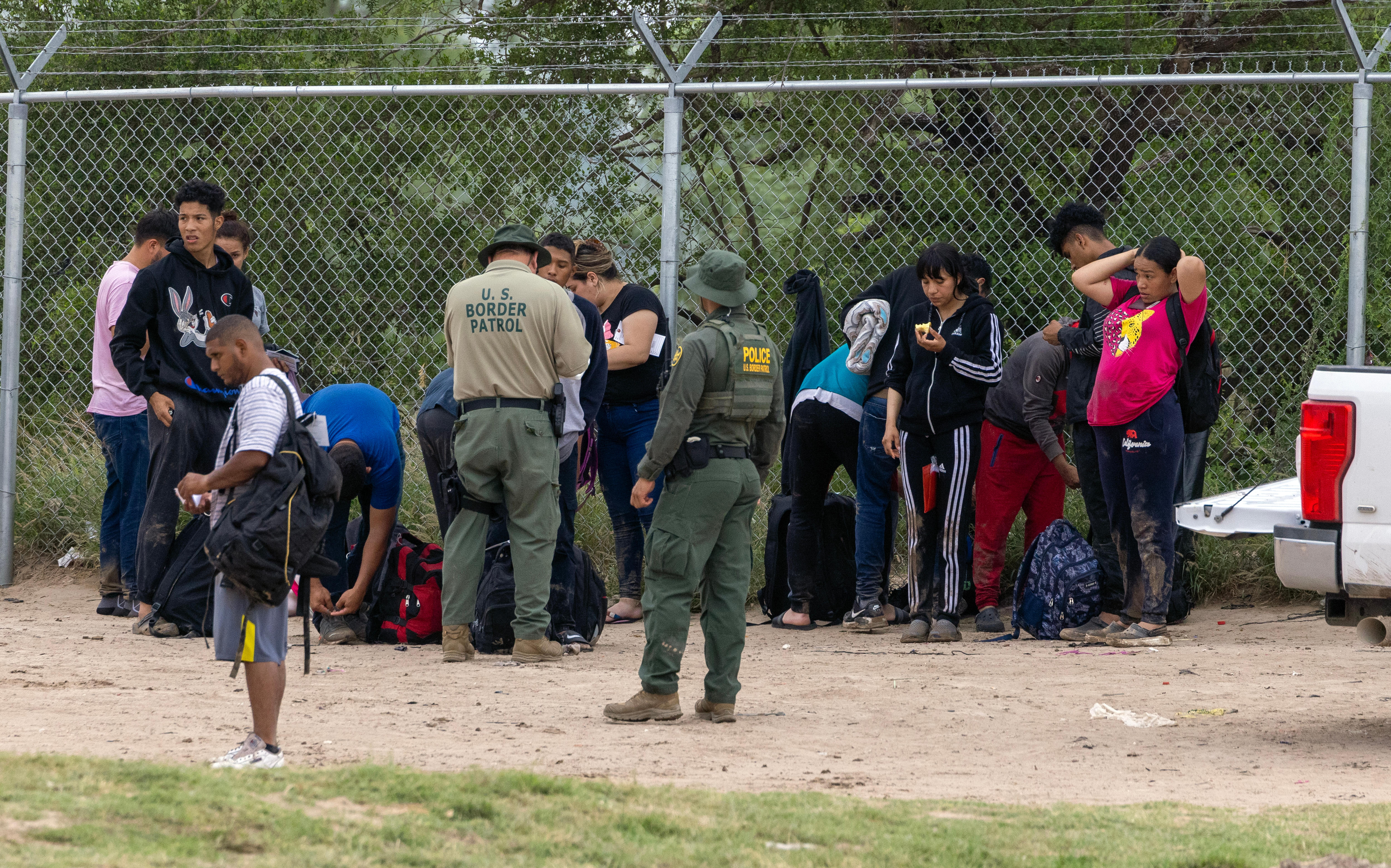 Eagle Pass (United States), 11/05/2023.- US Border Patrol Officer (C-L) and the Department of Public Safety Officer (DPS) (C-R) gather migrants who are trying to cross the border in Eagle Pass, Texas, USA, 11 May 2023. Title 42 which allowed the United States to block immigrants from coming in due to health risks ended on 11 May. (Estados Unidos) EFE/EPA/Adam Davis
