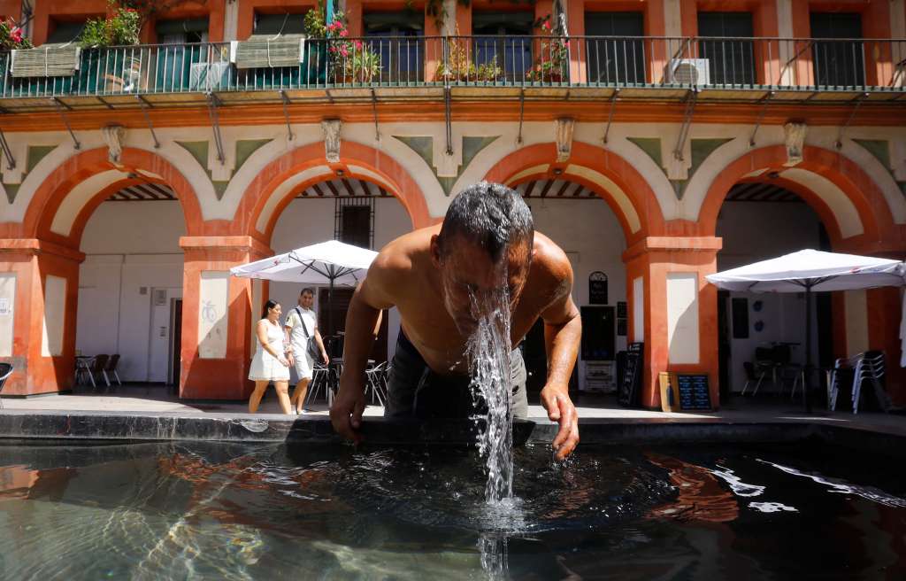 -FOTODELDÍA- GRAFAND2186. CÓRDOBA, 03/08/2022.- Un hombre se refresca en la fuente de la plaza de la Corredera de Córdoba cuando se cumple hoy miércoles el quinto día de la tercera ola de calor del verano con máximas que de nuevo rondarán los 40 grados en la zona centro, e incluso los superarán en buena parte de Extremadura y del valle del Guadalquivir. EFE/Salas