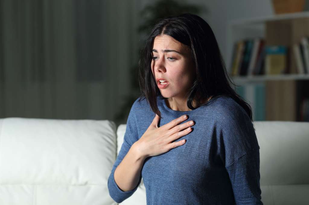 Woman suffering an anxiety attack alone in the night. Ataques de ansiedad, pánico