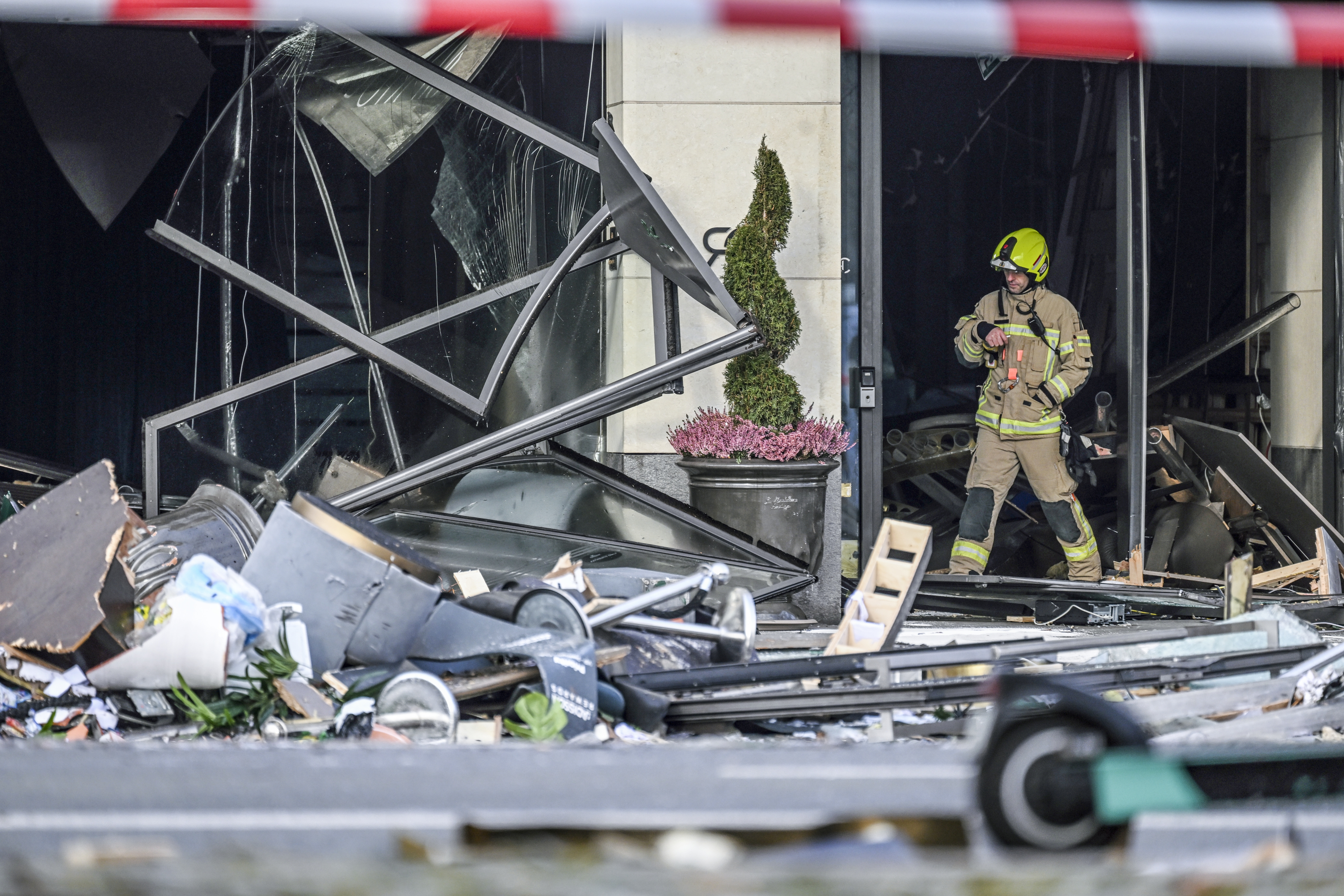 Berlin (Germany), 16/12/2022.- A fire fighter checks the damaged entrance of a hotel after a burst and leak of the AquaDom aquarium in Berlin, Germany, 16 December 2022. A 14-meter aquarium has burst at a hotel in downtown Berlin, injuring two people, German rescue services said. The home to around 1,500 exotic fish spills 1 million liters of water and floats a major road in the Mitte district, emergency services said. (Incendio, Alemania) EFE/EPA/FILIP SINGER