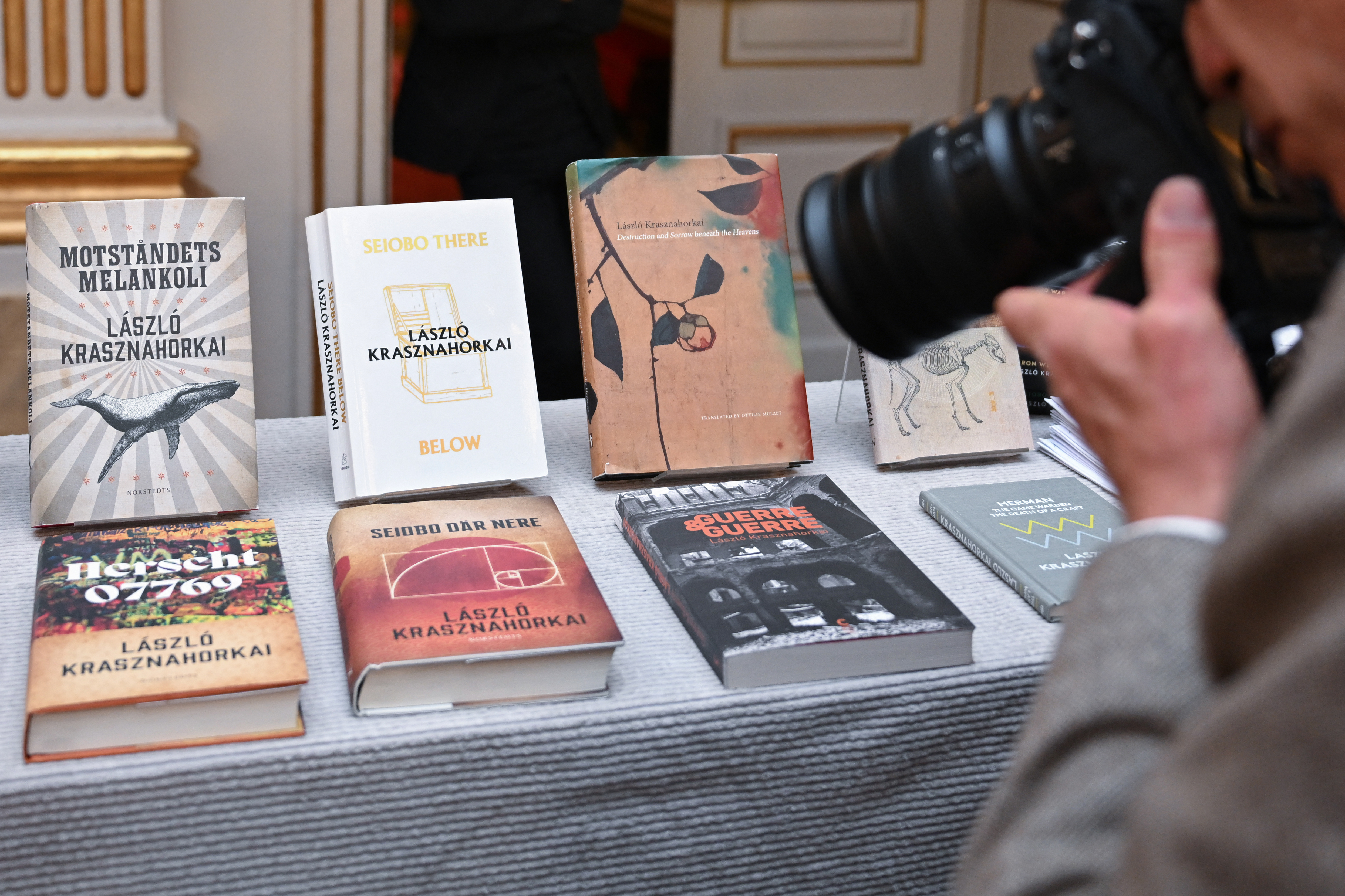 A photographer takes photos of Books of Hungarian writer Laszlo Krasznahorkai, the winner of the 2025 Nobel Prize in Literature, on display at the Swedish Academy in Stockholm, Sweden, on October 9, 2025. (Photo by Jonathan Nackstrand / AFP) / ALTERNATIVE CROP