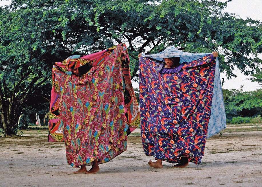 El libro contiene relatos de mujeres líderes, excombatientes, víctimas y niñas campesinas, afros e indígenas de Chocó, Antioquia, Atlántico, Norte de Santander, Bogotá, Caldas, Valle, La Guajira y otros departamentos. En la imagen, dos mujeres wayuú "bailando sobre la tierra".