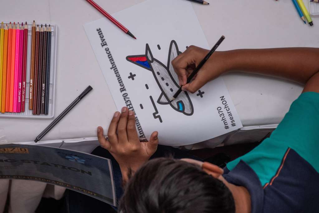 Subang Jaya (Malaysia), 03/03/2024.- A boy colours a drawing of missing Malaysia Airlines flight MH370 during a remembrance event marking the 10th anniversary of its disappearance at the Empire Subang in Subang Jaya, Selangor, Malaysia, 03 March 2024. About 200 people, including family members of missing passengers and Malaysia'Äôs Transport Minister Loke Siew Fook, attended the memorial event marking the 10th year after Malaysia Airlines flight MH370, carrying 12 crew members and 227 passengers, disappeared on its way from Kuala Lumpur to Beijing on 08 March 2014. (Malasia) EFE/EPA/NAZRI MOHAMAD