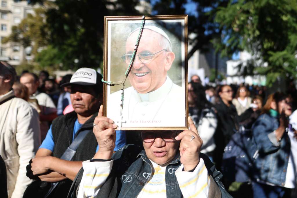 AME2631. BUENOS AIRES (ARGENTINA), 26/04/2025.- Una mujer sostiene un retrato del papa Francisco durante una caravana en su honor este sábado, al rededor de la Plaza de Mayo en Buenos Aires (Argentina). "Lloramos porque se murió el padre de todos, lloramos porque no terminamos de dimensionar y comprender su liderazgo internacional", dijo este sábado el arzobispo de Buenos Aires, Jorge García Cuerva, en la emotiva misa exequial por el papa Francisco celebrada en la catedral de la capital argentina. EFE/ Juan Ignacio Roncoroni