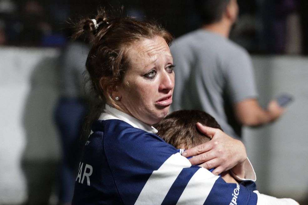 Una mujer abraza a su hijo en medio de los incidentes en el partido Gimnasia y Esgrima vs. Boca Juniors. (Photo by ALEJANDRO PAGNI / AFP)