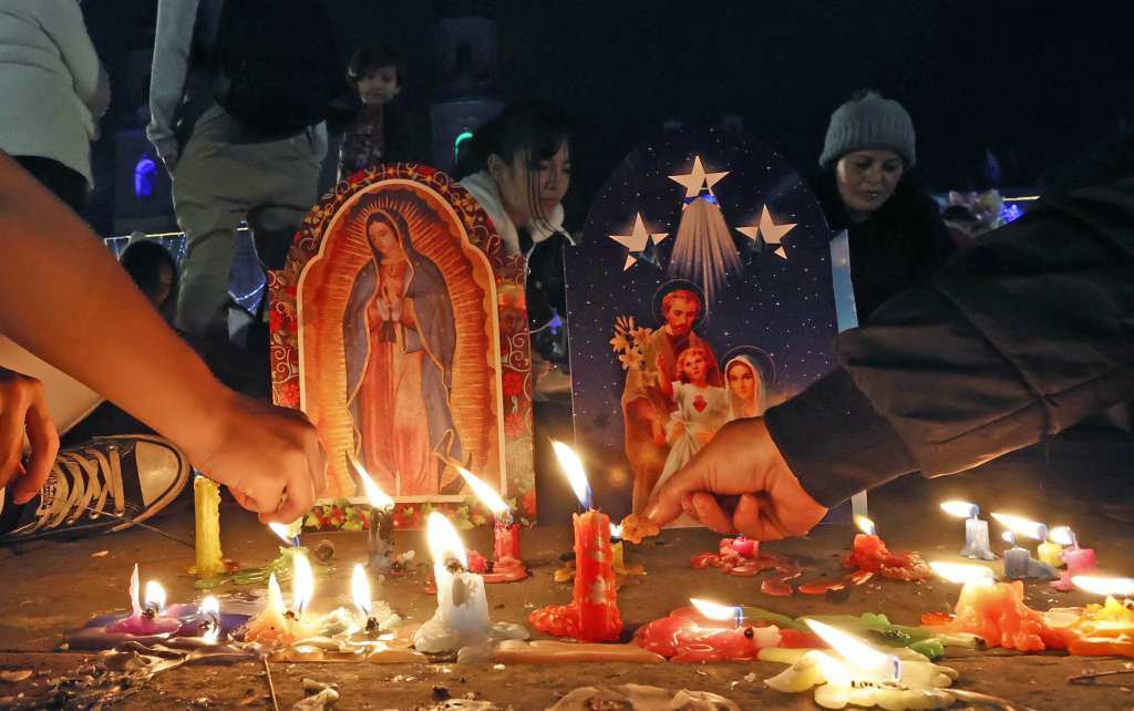 AME4042. BOGOTÁ (COLOMBIA), 07/12/2024.- Personas encienden velas durante la tradicional Noche de las Velitas este sábado en Bogotá (Colombia). La tradicional Noche de las Velitas, que marca el inicio de la Navidad en Colombia, se vivió este sábado en el que familias a lo largo y ancho del país se reunieron en viviendas, edificios, plazas y parques para compartir comida y golosinas y disfrutar de los alumbrados navideños. EFE/Mauricio Dueñas Castañeda