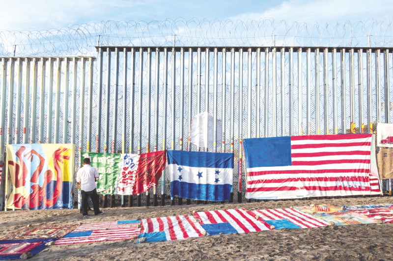 An exhibit by local artist Robenz and Central American migrants is on display on the beach next to a section of the US-Mexico border fence as seen from Tijuana, in Baja California state, Mexico, on January 8, 2019. President Donald Trump tells Americans in a primetime speech Tuesday that the US-Mexico border is in "crisis" and Congress must approve construction of a wall to end a government shutdown now in its 18th day. / AFP / Guillermo Arias