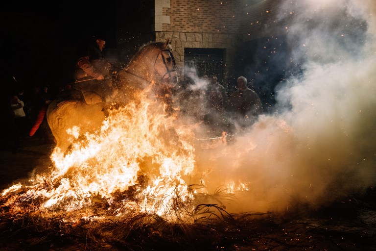 FOTOGALERÍA 9 DE 10.- SAN BARTOLOMÉ DE PINARES (ÁVILA), 16/01/2023.- Un jinete pasa con su caballo por encima de las llamas durante las tradicionales "luminarias" que se celebran hoy lunes en la localidad abulense de San Bartolomé de Pinares. EFE / Raúl Sanchidrián.