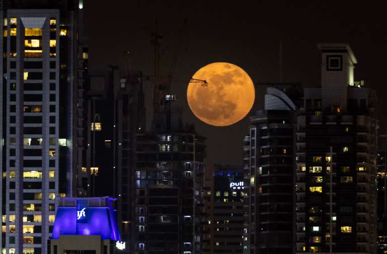 La luna llena, conocida como la «Luna de fresa», se eleva sobre el horizonte de Dubai el 11 de junio de 2025.