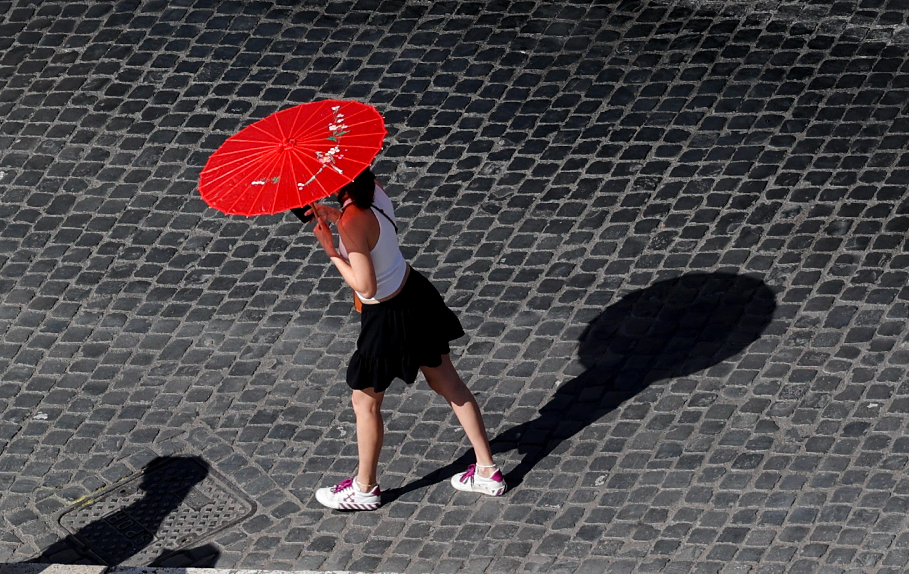 -FOTODELDÍA- ROMA, 28/07/2024.- Una mujer porta una sombrilla para protegerse del sol en un caluroso día, este domingo, en Roma. Las previsiones meteorológicas alertan de temperaturas de 40 grados en toda Italia. EFE/GIUSEPPE LAMI